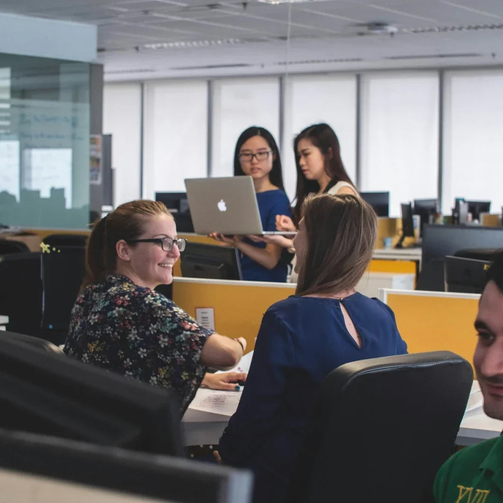 Équipe de collaborateurs échangeant dans un open space, illustrant la motivation des salariés, la qualité de vie au travail (QVT) et les récompenses en entreprise.