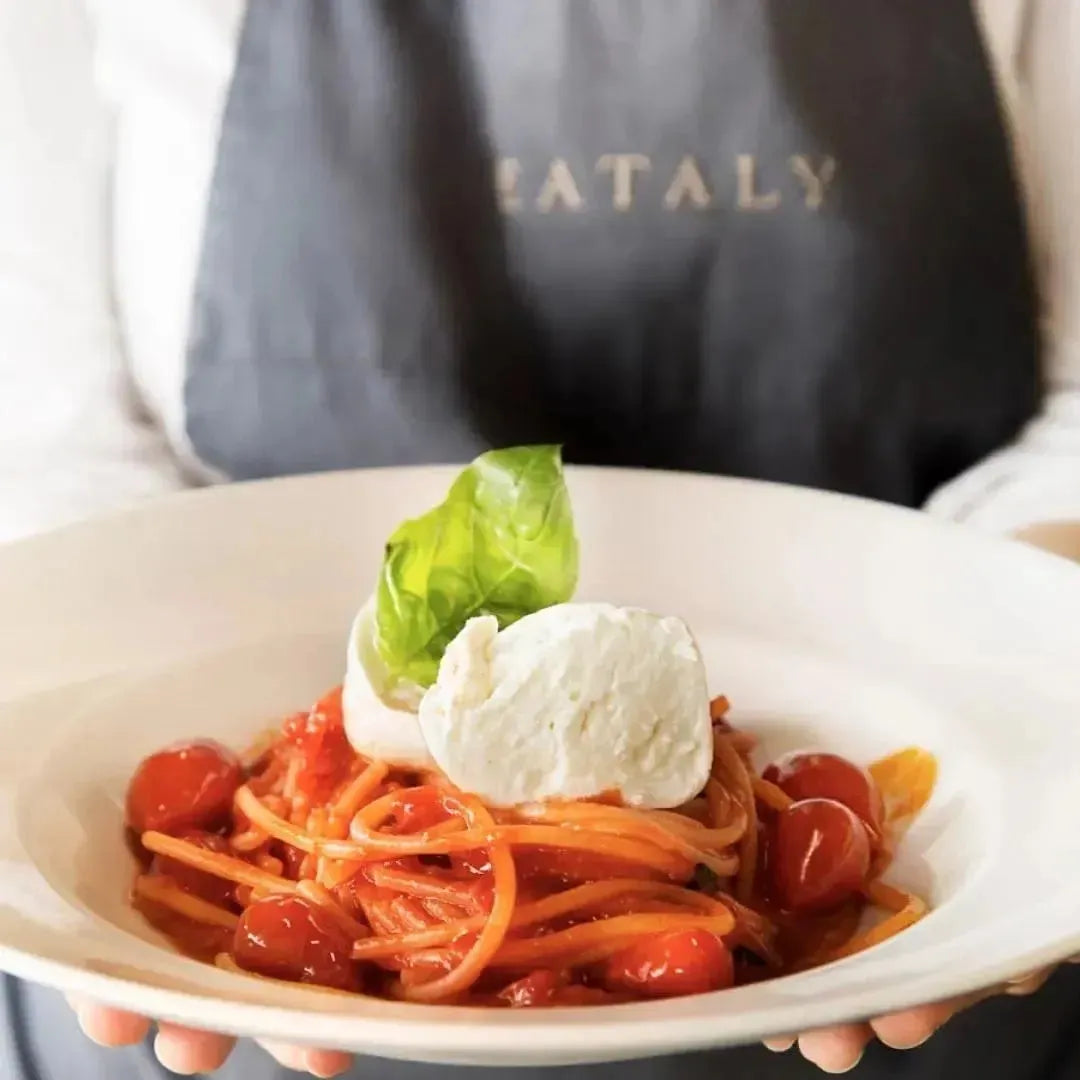 Serveuse portant un plat de spaghetti mozzarella 
